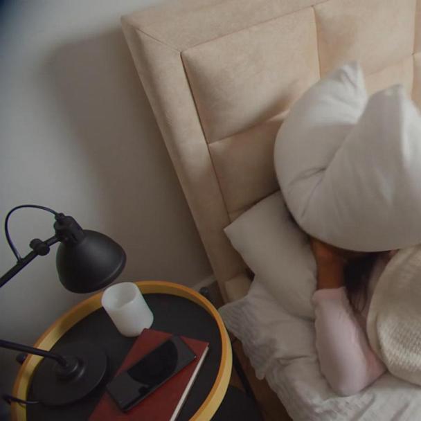 Person i soveværelse der signalerer træthed og dårlig søvn